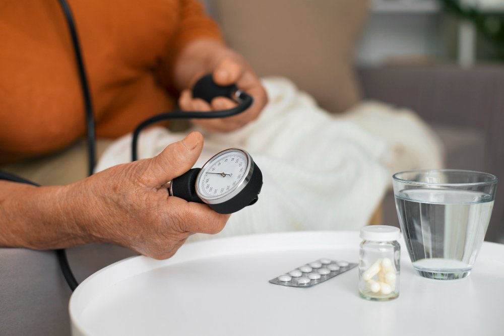 A woman measuring their blood pressure while sitting.