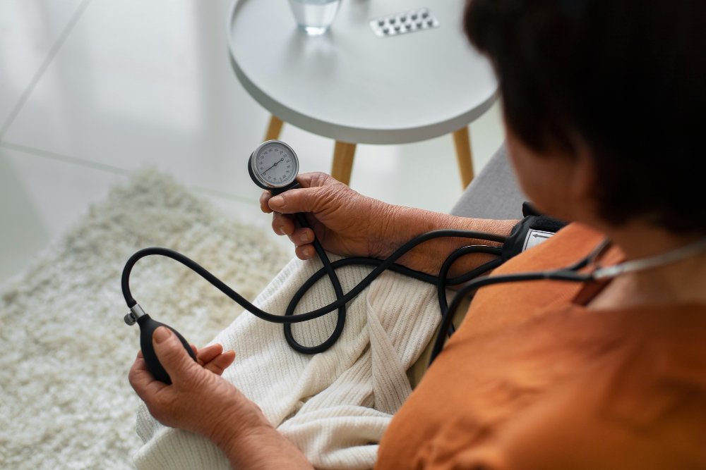 An old-age women monitoring Blood Pressure using a manual blood pressure monitor