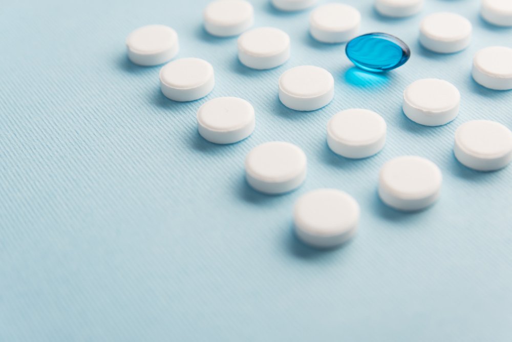 white pills on a flat surface, prefectly arranged at a distance to each other