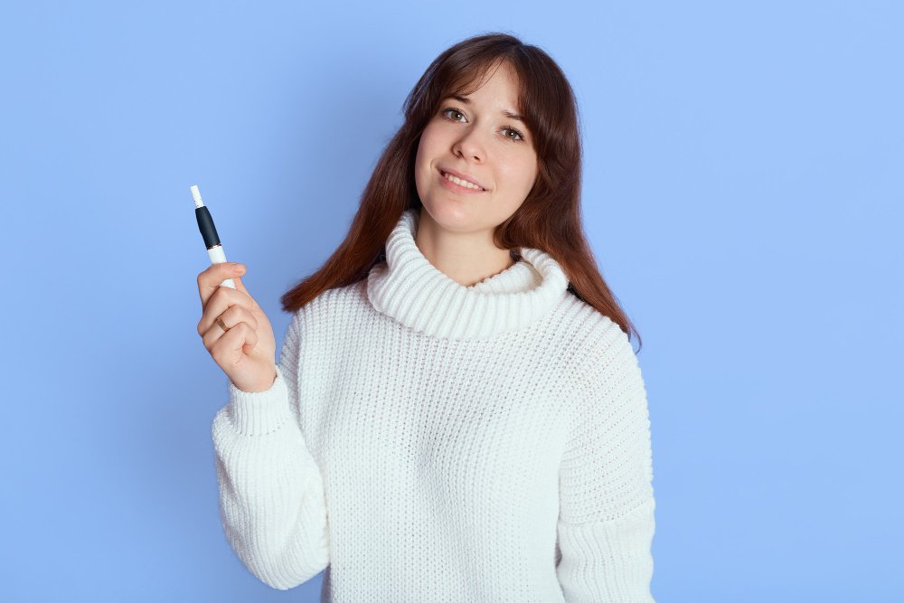A girl with a white hoodie holding a medication device