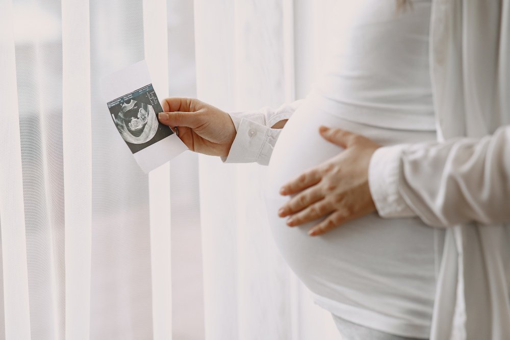 A pregnant woman looking at an ultrasound image of their baby
